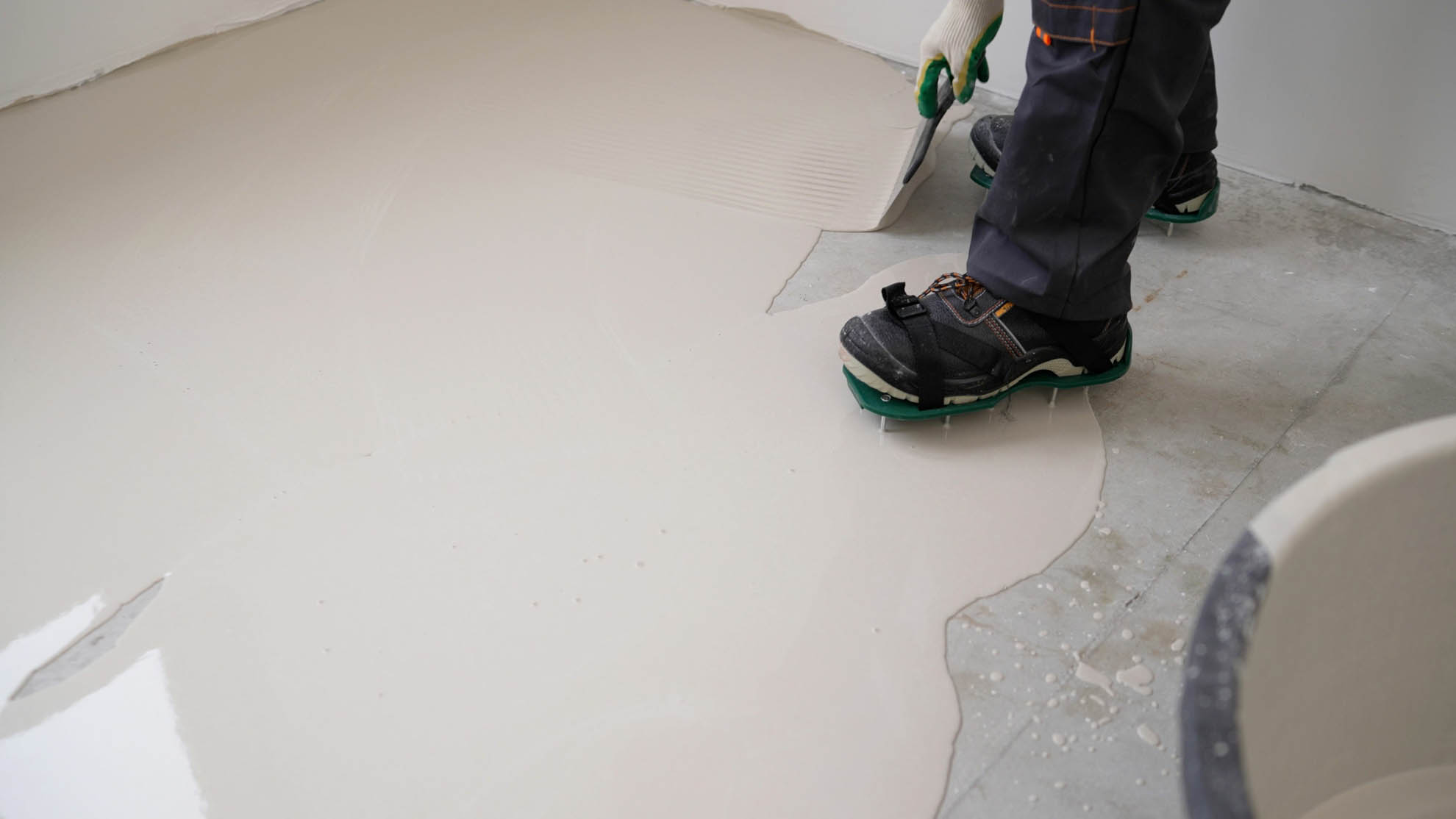Spreading self leveling compound with trowel. Self-leveling epoxy. Leveling with a mixture of cement floors. Leveling liquid floors with a trowel.